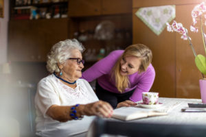 Young woman caregiver spending time with a senior woman at home