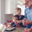 Family caregiver assists her children and her elderly father make cookies during the holidays
